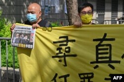 Supporters of two executives from Hong Kong's Apple Daily newspaper, chief editor Ryan Law and CEO Cheung Kim-hung, protest outside court in Hong Kong on June 19, 2021.