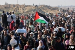 Orang-orang berjalan di sepanjang Jalan al-Rashid di pesisir Gaza untuk menyeberangi koridor Netzarim dari Jalur Gaza selatan ke utara pada 27 Januari 2025. (Omar AL-QATTAA / AFP)