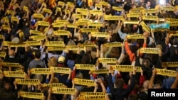 People hold banners reading "Freedom Political Prisoners" gather in support of the members of the dismissed Catalan cabinet after a Spanish judge ordered the former Catalan leaders to be remanded in custody pending an investigation into Catalonia's independence push, outside Barcelona's town hall, Nov. 3, 2017.
