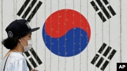 A woman wears a mask as a precaution against Middle East Respiratory Syndrome (MERS) in Seoul, South Korea, June 11, 2015.