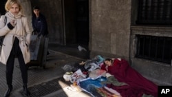 Una persona duerme en una acera en el centro de Buenos Aires, Argentina, el lunes 24 de junio de 2024. 