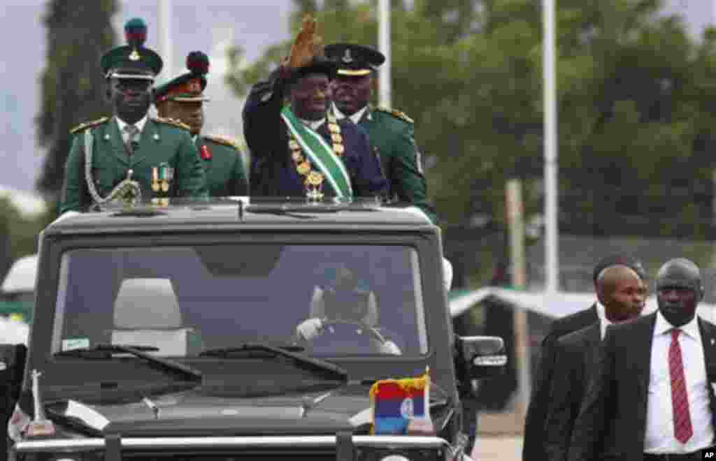 Nigeria President Goodluck Jonathan, center, waves to the crowds during his inauguration ceremony at the main parade ground in Nigeria's capital of Abuja, Sunday, May 29, 2011. Jonathan was sworn in Sunday for a full four-year term as president of Nigeria