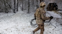 Seorang tentara Ukraina membawa satu unit Starlink di garis deopan pertempuran di Kreminna, Ukraina, pada 6 Januari 2023. (Foto: Reuters/Clodagh Kilcoyne)