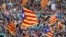 Manifestantes agitan banderas separatistas catalanas durante una manifestación organizada por los movimientos independentistas catalanes, tras el encarcelamiento de sus dos líderes Jordi Sánchez y Jordi Cuixart, en Barcelona, el 21 de octubre de 2017.