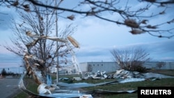 Potongan metal dan plastik dari gedung di wilayah Bowling Green, Kentucky, yang hancur diterpa tornado pada 10 Desember 2021, tampak menyangkut pada pohon dan bertebaran di mana mana dalam foto yang diambil pada 11 Desember 2021. (Foto: Reuters/Amira Karaoud)