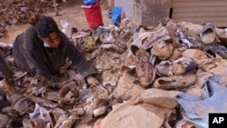 A woman looks though discarded shoes after floods in Catarroja on the outskirts of Valencia, Spain, Nov. 5, 2024.