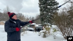 ARCHIVO - Una persona despeja la nieve del techo de su casa en North Perry, Ohio el 3 de diciembre del 2024. (AP foto/Patrick Aftoora-Orsagos).