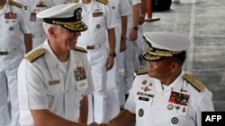 美国第七舰队司令卡尔·托马斯中将（左）和菲律宾海军 2023“萨玛萨玛”演习司令官托里比奥·阿达西中将（中）在美菲年度海军演习的开幕式上握手。（2023年10月2日）