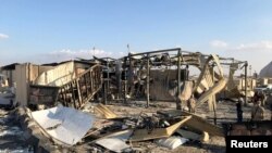 Abasirikare b'Amerika bariko bagenzura ahatewe misile kw'ikambi ya Ain al-Asad mu ntara ya Anbar, muri Iraki, kw'itariki 13/01/2020.