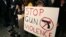 Sophie Bell, 9, holds a sign during an interfaith candlelight prayer vigil to end gun violence in front of Los Angeles City Hall in Los Angeles, California, December 19, 2012.