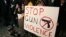 Sophie Bell, 9, holds a sign during an interfaith candlelight prayer vigil to end gun violence in front of Los Angeles City Hall in Los Angeles, California, December 19, 2012.