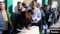 Palestinian Hamas-hired employees wait to receive salaries for the first time in years, in the southern Gaza Strip, Nov. 9, 2018. 