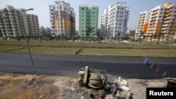 Laborers work at the construction site of a residential complex on the outskirts of Kolkata, India, Jan. 29, 2018. 