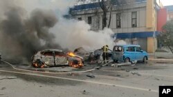 In this photo taken from video released by the Russia Emergency Situations Ministry's Telegram channel on Dec. 30, 2023, firefighters extinguish burning cars after shelling in Belgorod, Russia.