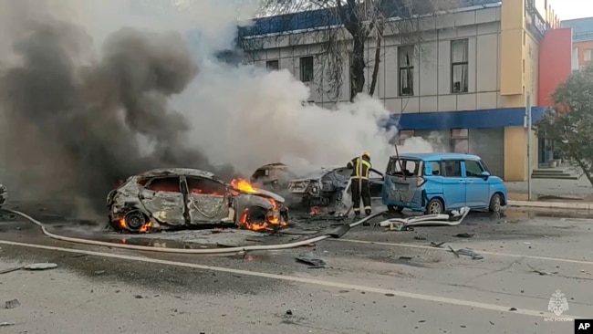 In this photo taken from video released by the Russia Emergency Situations Ministry's Telegram channel on Dec. 30, 2023, firefighters extinguish burning cars after shelling in Belgorod, Russia.