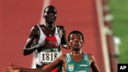 Paul Tergat du Kenya poursuit l’Ethiopien Haile Gebreselassie sur la ligne d’arrivée de l’épreuve des 10.000 mètres aux Jeux olympiques d'été de 1996 à Atlanta, le lundi 29 Juillet, 1996.