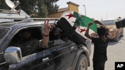 Members of Turkey-backed Syrian National Army (former FSA) flash the V-sign as they drive back to Turkey near the border between Turkey and Syria, in Akcakale, Sanliurfa province, southeastern Turkey, Oct. 9, 2019.