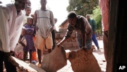 Des survivants d’un séisme qui a frappé l’est de l’Afrique constatent les dégâts sur leur maison à Kalémie, République démocratique du Congo, 7 décembre 2005.