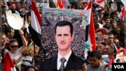 Medios de comunicación estatales reportaron que multitudes ondean banderas sirias a favor de Assad.