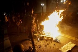 A protester walks past a bonfire set at an intersection during a Black Lives Matter protest at the Mark O. Hatfield United States Courthouse July 25, 2020, in Portland, Ore.