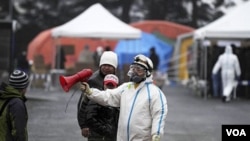 Petugas di Fukushima mengenakan baju khusus anti-radiasi, Selasa (15/3).