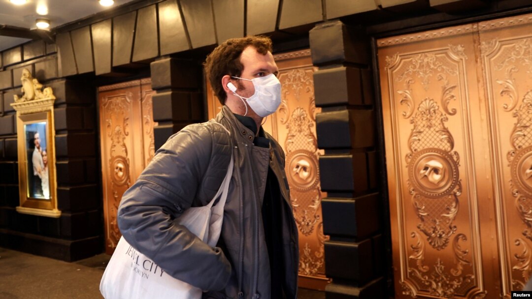 Seorang pria dengan masker berjalan melewati teater yang tutup setelah diumumkan bahwa pertunjukan Broadway akan membatalkan pertunjukan karena corona di New York, AS, 12 Maret 2020. (Foto: Reuters/Mike Segar)