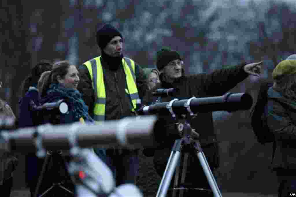 People wait in the early morning light beside telescopes to view the partial solar eclipse from Parliament Hill on Hampstead Heath in London, Tuesday, Jan. 4, 2011. Cloudy skies hung over London on Tuesday morning, preventing a view from Parliament Hill 