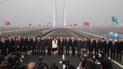 2026년 10월 24일 김정은 북한 국무위원장의 중국 랴오닝성 단둥 방문 중, 김정은 위원장과 왕후닝 중국 인민정치협상회의(정협) 전국위원회 의장, 왕이 중국 외교부장, 최선희 북한 외무상이 중국 단둥과 북한 신의주를 잇는 신압록강대교에서 관계자들과 함께 기념사진을 찍고 있다.
