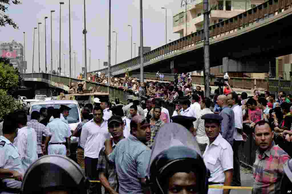 Egyptian security forces and civilians gather near the scene after a roadside bomb went off on a busy street in downtown near the foreign ministry in Cairo.