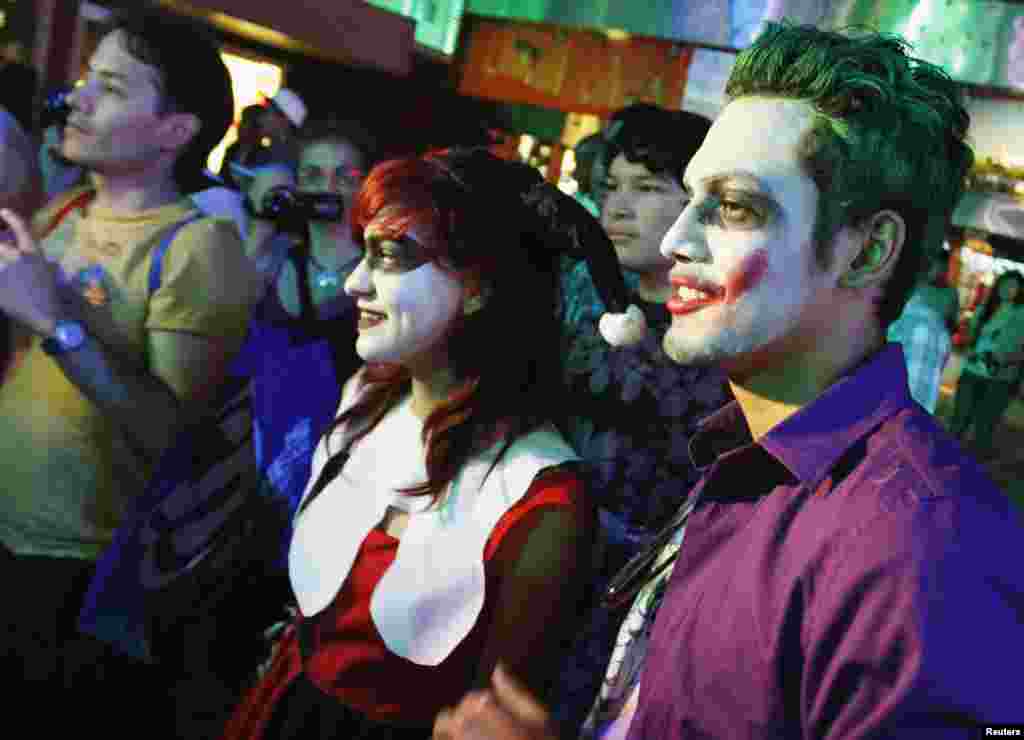 Vestidos como Harley Quinn y el Guas&oacute;n, estos espectadores se preparan para el estreno.