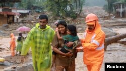 Rescuers help residents to move to a safer place, at a landslide site after multiple landslides in the hills, in Wayanad, in the southern state of Kerala, India, July 30, 2024. 