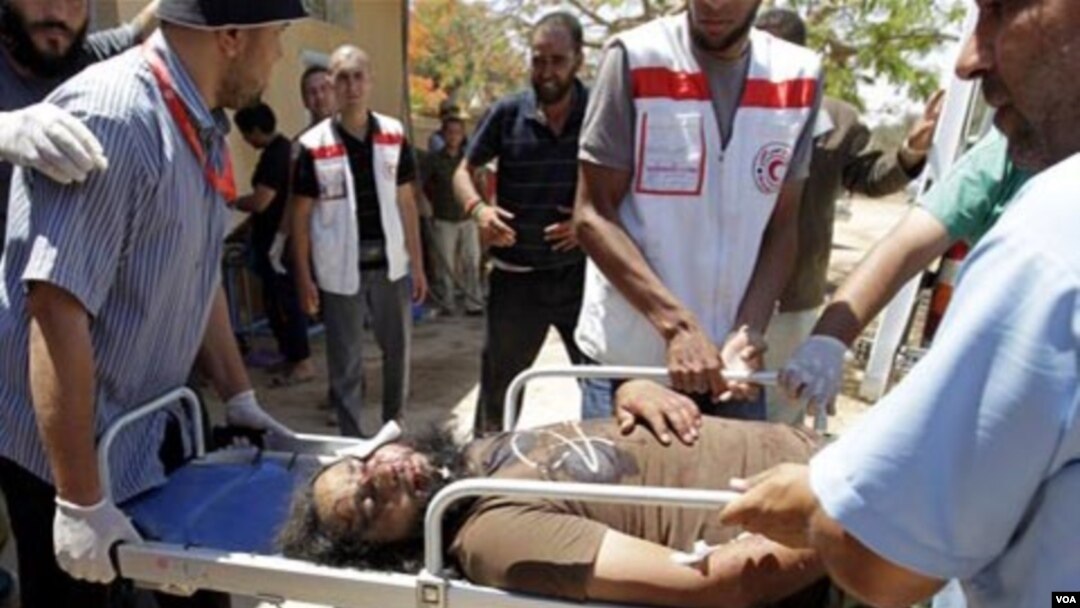 Petugas medis mengangkut seorang anggota pasukan pemberontak Libya yang terluka di pinggiran kota Misrata.