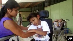 Marielos Sandi, left, helps care for Mora Chavaria, right, on International Women's Day at the National Rehabilitation Center in Santa Ana, Costa Rica.