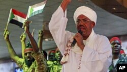 Supporters wave flags as Sudanese President Omar al-Bashir addresses a rally in Khartoum, Sudan, April 18, 2012.