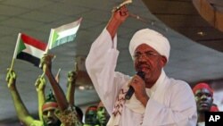 Supporters wave Sudanese flags as Sudanese President Omar al-Bashir addresses supporters during a rally at the ruling National Congress Party headquarters in Khartoum, Sudan, April 18, 2012.