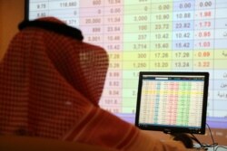 A saudi man looks to the computer showing stock prices at ANB Bank, in Riyadh, Saudi Arabia, Sept. 15, 2019.
