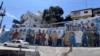 ARCHIVO - Un mural que representa a fuerzas de seguridad junto a trabajadores de servicios públicos cubre una pared en una calle que conduce al barrio Cerro de Santa Ana en Guayaquil, Ecuador, el 4 de febrero de 2025. AP