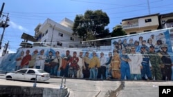 ARCHIVO - Un mural que representa a fuerzas de seguridad junto a trabajadores de servicios públicos cubre una pared en una calle que conduce al barrio Cerro de Santa Ana en Guayaquil, Ecuador, el 4 de febrero de 2025. AP