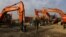A man walks next to machinery parked at the Omid Gardizi construction company in Kabul, Afghanistan, Nov. 30, 2015.