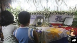 Reynalyn Dagsa, left, and Andrew Dagsa, children of Reynaldo Dagsa, pray beside the coffin of their slain father during his wake at their residence at Caloocan city north of Manila, Philippines, 4 Jan 2011