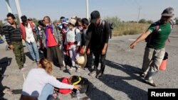 Un migrante es atendido luego de ser herido durante un altercado entre agentes del Instituto Nacional de Migración (INM) de México y migrantes que viajaban en una caravana hacia la Ciudad de México, en San Matías Tlalancaleca, México, el 10 de diciembre de 2021.