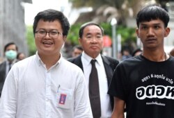 Anon Nampa, left, and Panupong Jadnok, right, two of the leaders of recent anti-government protests, are seen after being granted a bail outside the criminal court in Bangkok, Thailand, Aug. 8, 2020.