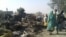 People return to the site after a bombing attack by a Nigerian military jet of an internally displaced persons camp in Rann, Nigeria Jan. 17, 2017. Officials say the bombing was an accident and is under investigation.