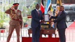 Presiden Kenya William Ruto menyerahkan konstitusi Kenya kepada Wakil Presiden Kithure Kindiki setelah ia mengambil sumpah jabatan dalam upacara pelantikannya, 1 November 2024.