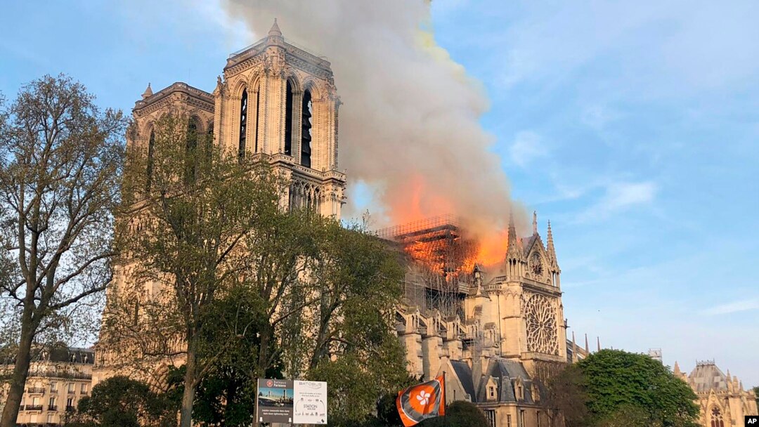 Notre Dame cathedral is burning in Paris, April 15, 2019. Massive plumes of yellow brown smoke is filling the air above Notre Dame Cathedral and ash is falling on tourists and others around the island that marks the center of Paris. 