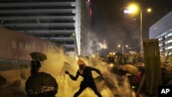 A protester throws a tear gas canister which was fired by riot police during a rally in Hong Kong, July 28, 2019.