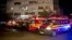 Ambulances are parked outside the site of an explosion that occurred in a club, housed by the building in the background, in Bucharest, early Saturday, Oct. 31, 2015.