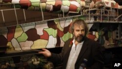 Director Peter Jackson points out a multi-colored cannon used during the early days of the World War I at the museum exhibition he has created, April 17, 2015, in Wellington, New Zealand. 