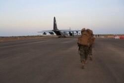 FILE - U.S. Marines and sailors prepare to board a KC-130J Marine Super Hercules at Camp Lemonnier, Djibouti, Dec. 24, 2013, in this image released by the U.S. Department of Defense.