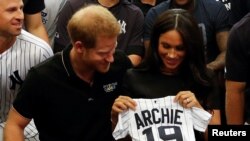 Pangeran Harry dan istrinya, Meghan, menerima hadiah untuk bayi laki-laki mereka, Archie, saat bertemu para pemain New York Yankees di London, Inggris, 29 Juni 2019. 